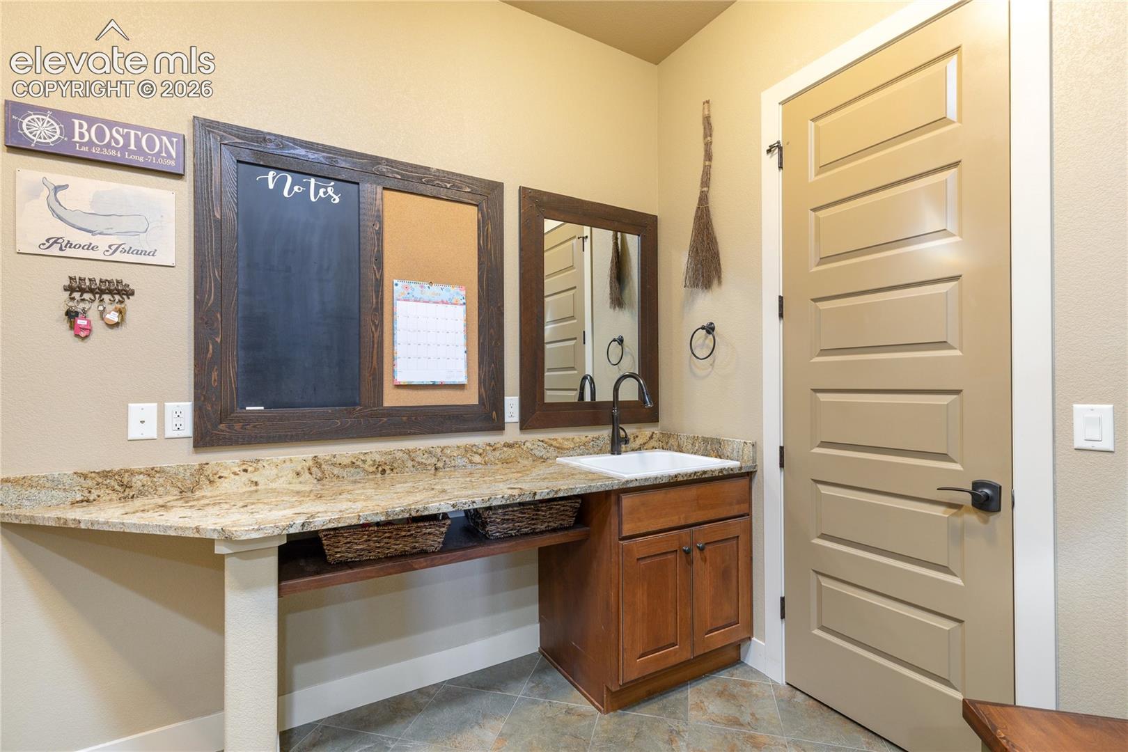 Custom built-in bench seating, storage cubbies + dedicated coat storage transform the mudroom into a beautifully functional transition space, blending practical convenience with the home's distinctive cabinetry + craftsmanship.