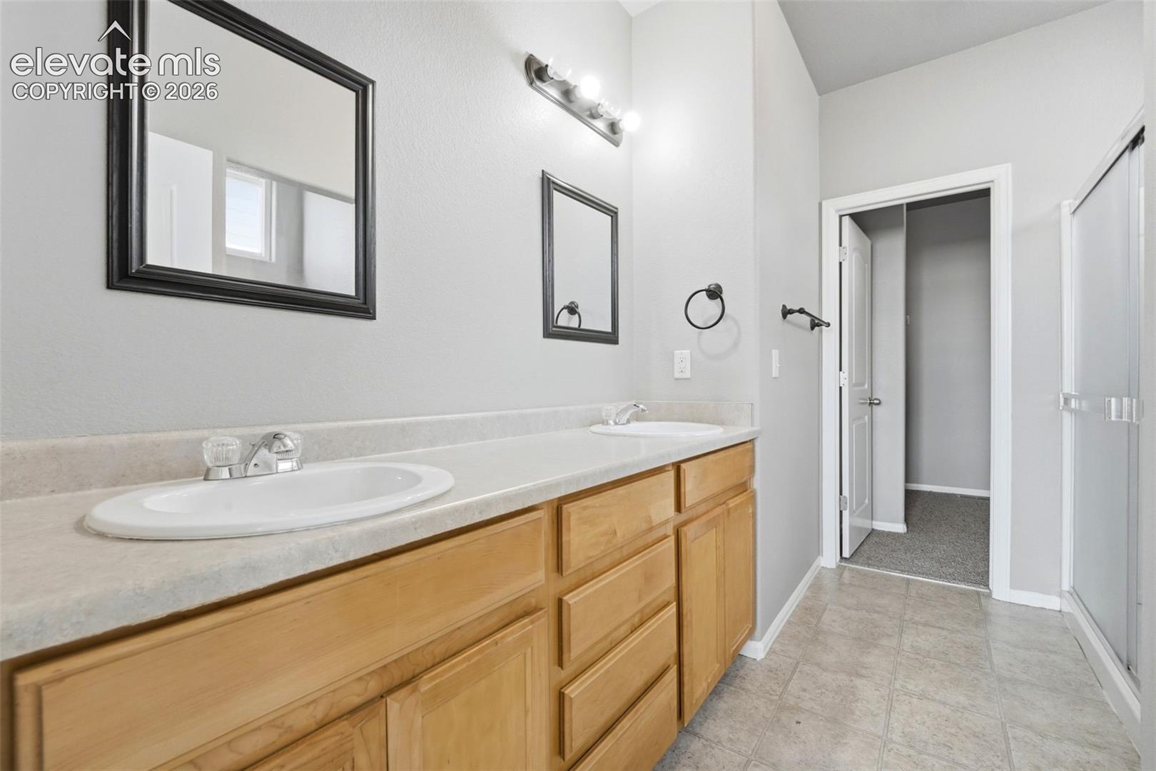 Dual vanity with light-tone wood cabinetry
