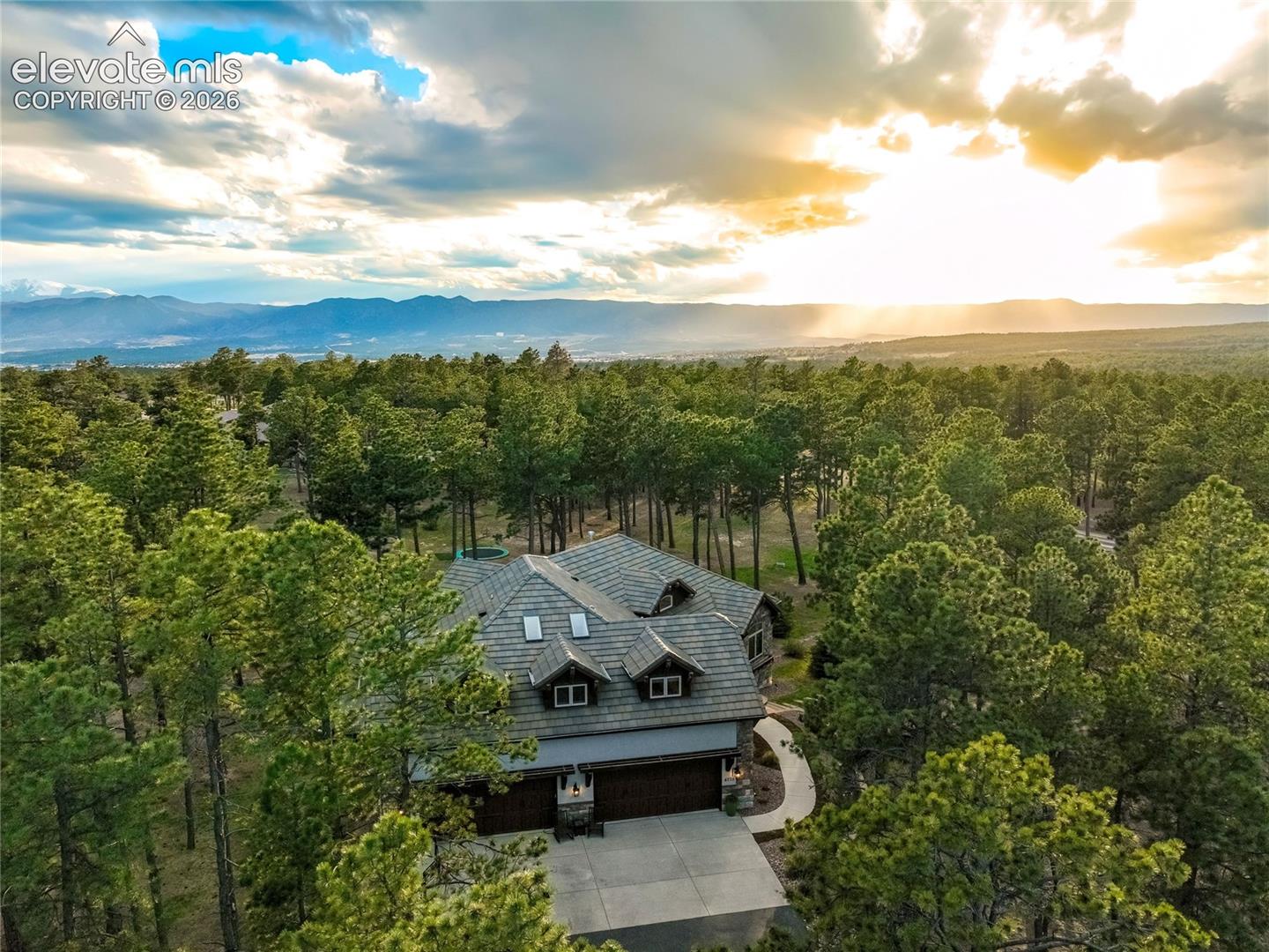 Timeless architecture harmonizes with towering pines and expansive Colorado skies across 2.5 acres - peaceful and private, yet close to modern conveniences and trail systems.