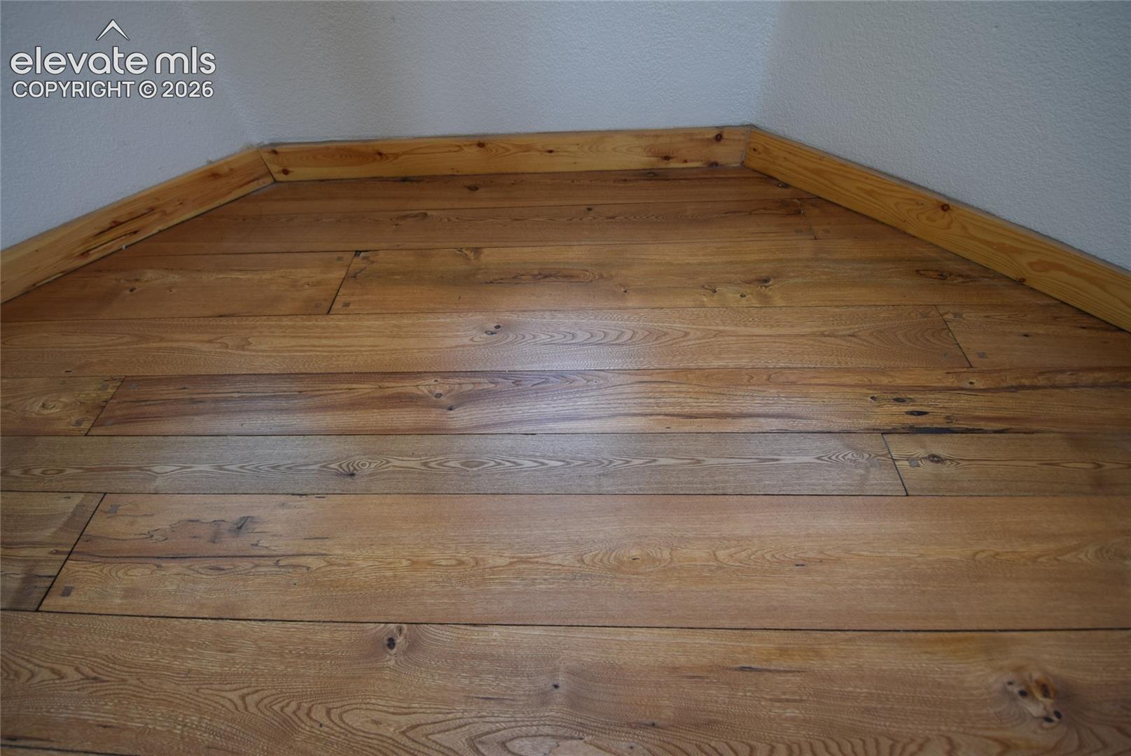 Wood-finish flooring with natural graining and light-toned wood trim