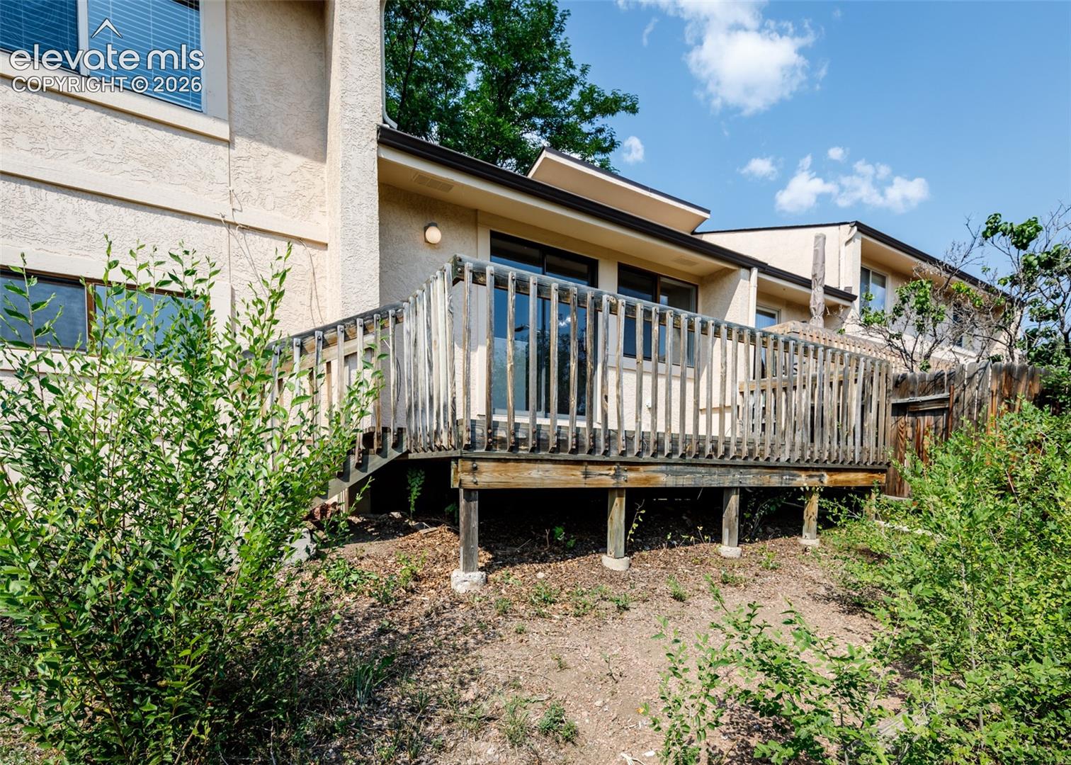 Expansive wooden deck with a slatted railing, providing outdoor access from the residence