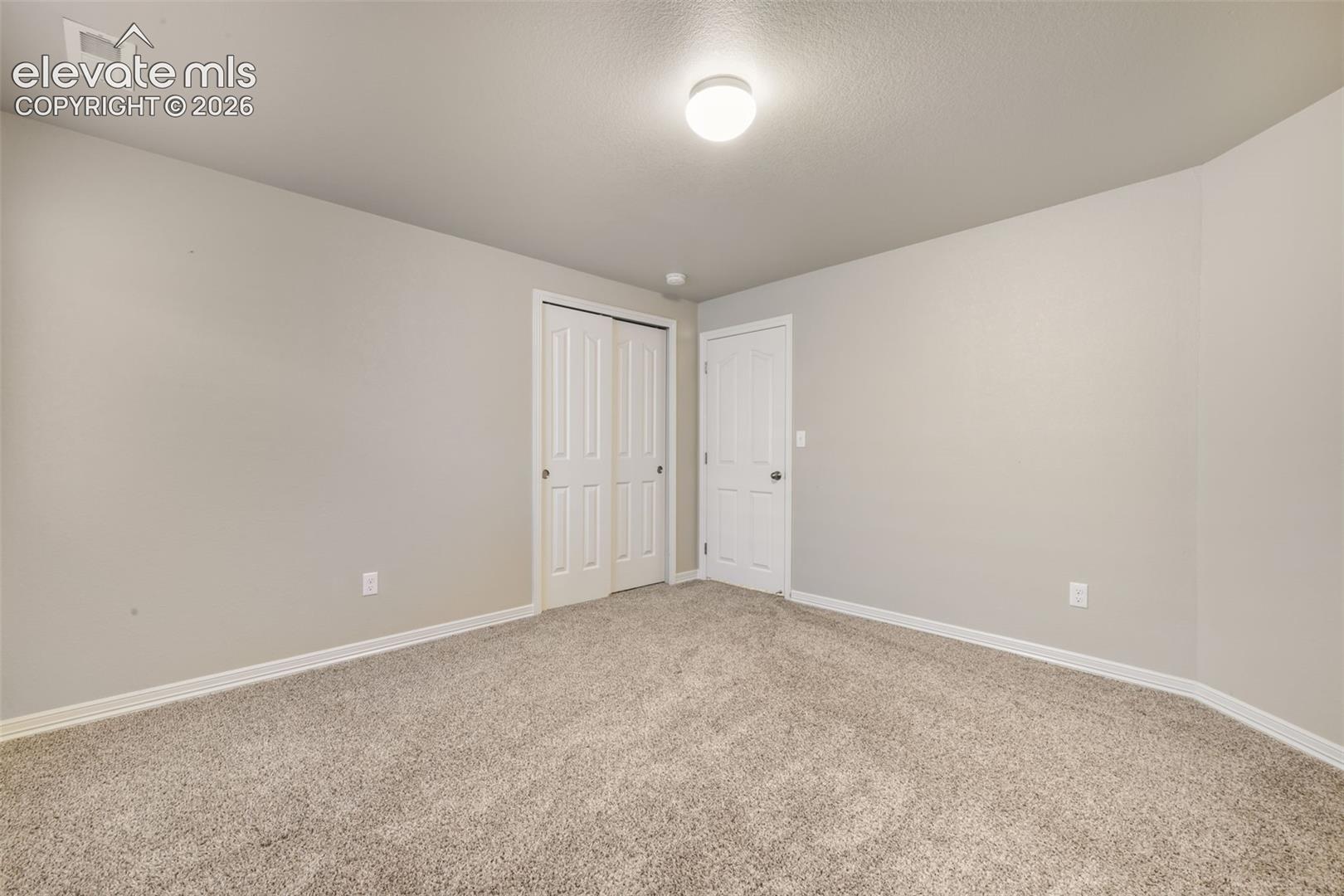 Neutral wall paint, plush carpeting, white trim, bi-fold closet doors, and recessed lighting