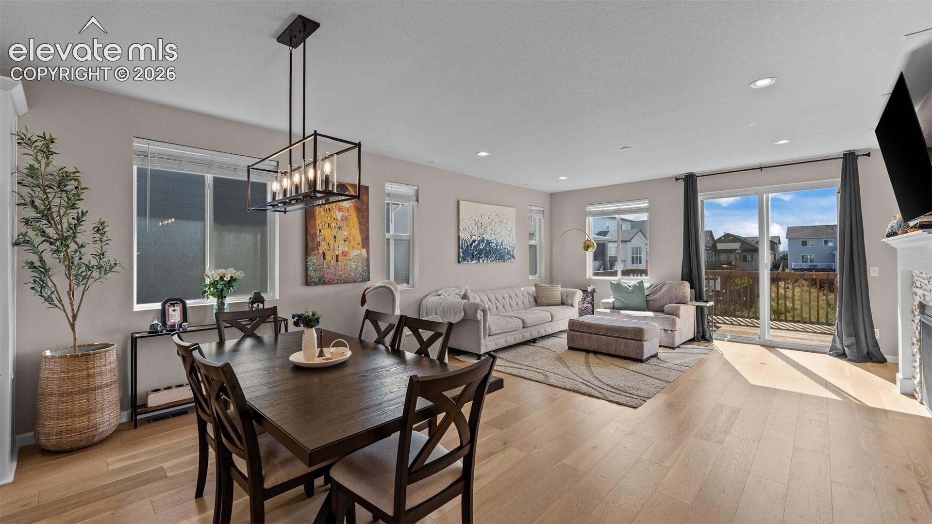 Open-concept living space featuring wood-finish flooring, recessed lighting, and a sliding glass door to a private deck