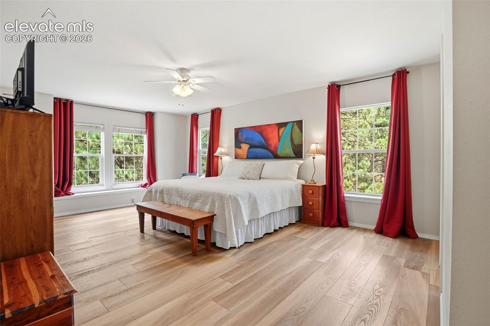 AS is spacious primary bedroom with newer flooring, window seat and ceiling fan.