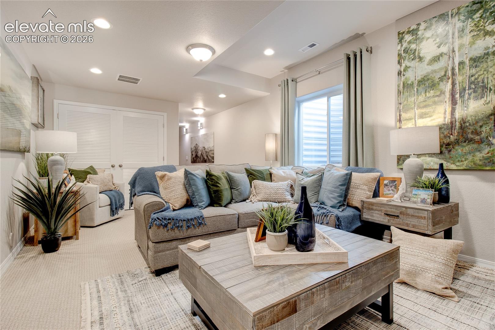 Neutral-toned interior space featuring recessed lighting, a sliding egress window with vertical blind tracks, and dual-panel interior doors