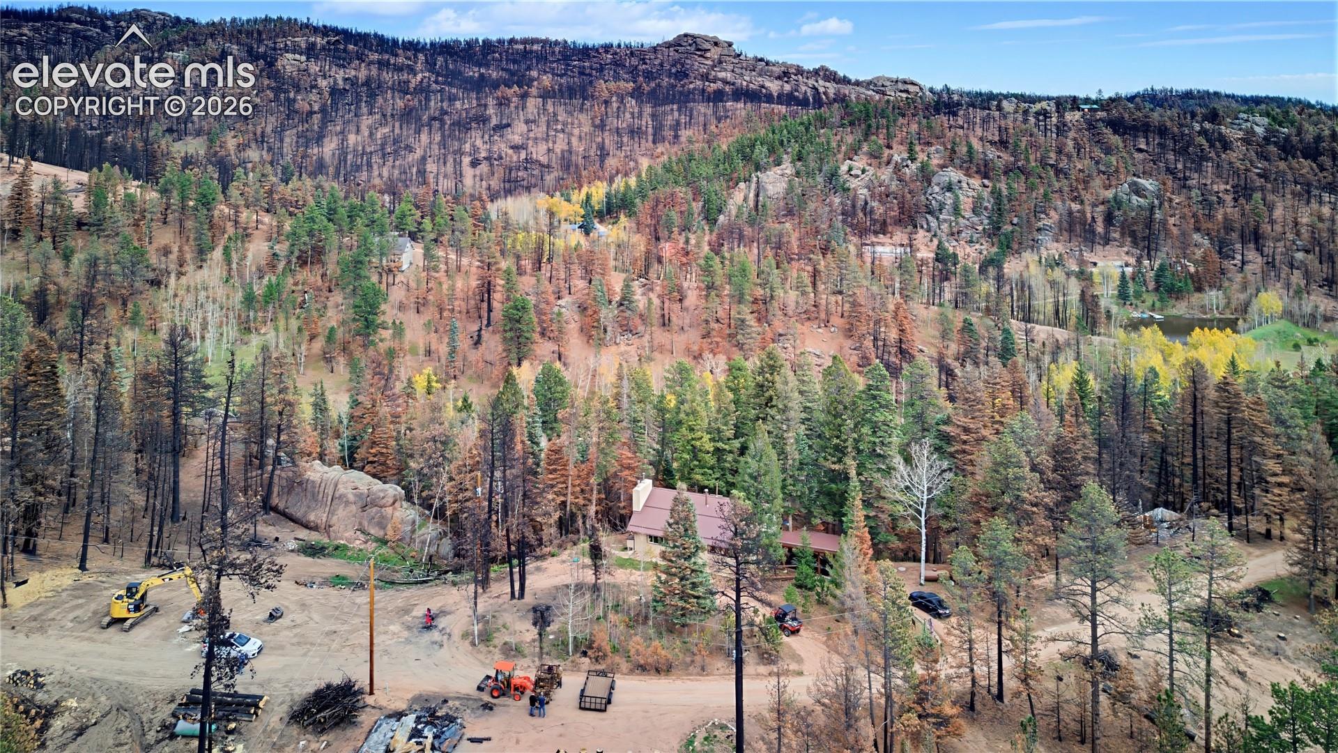 Expansive mountain acreage featuring rugged terrain, mature evergreen and deciduous trees, and large natural rock outcroppings