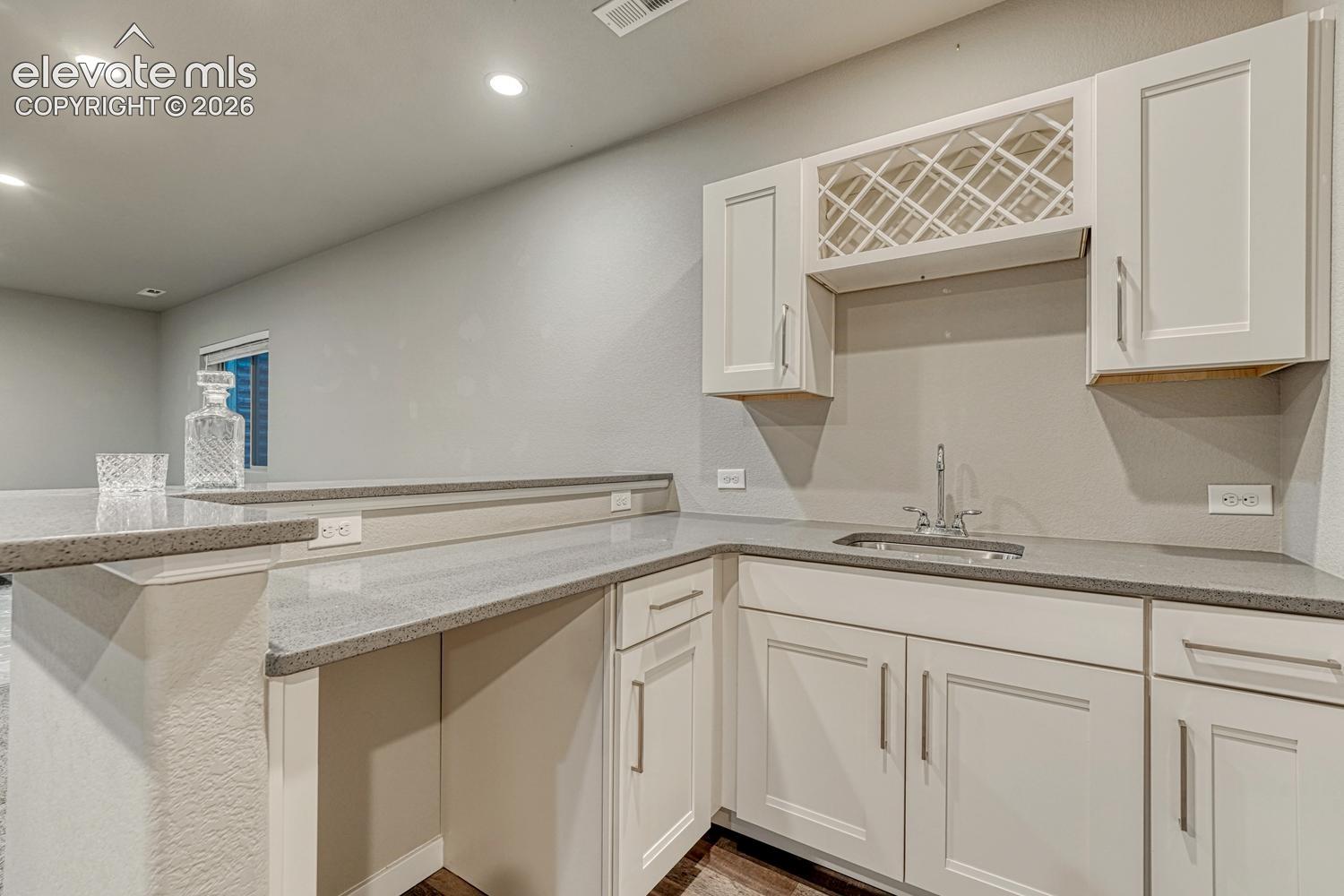 wet bar with quartz counters and custom cabinetry