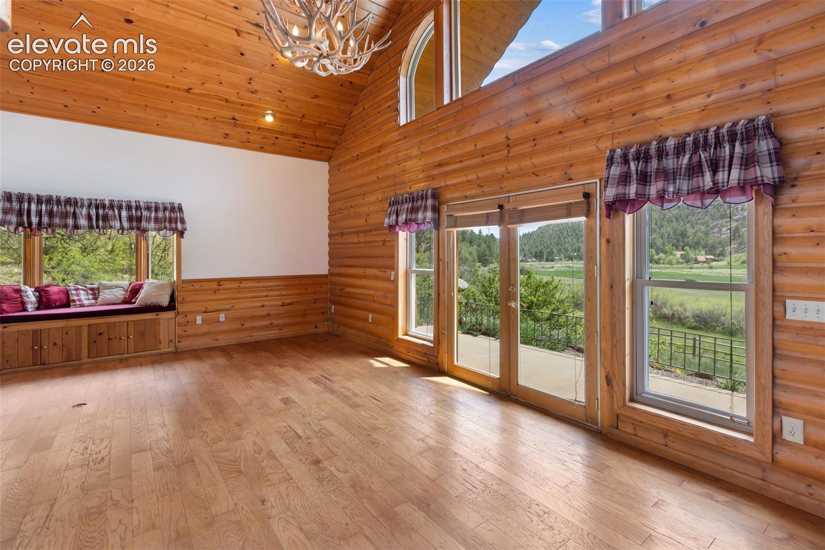 A warm, log-walled family room located just steps from the outdoors and the soothing sounds of a nearby stream.
