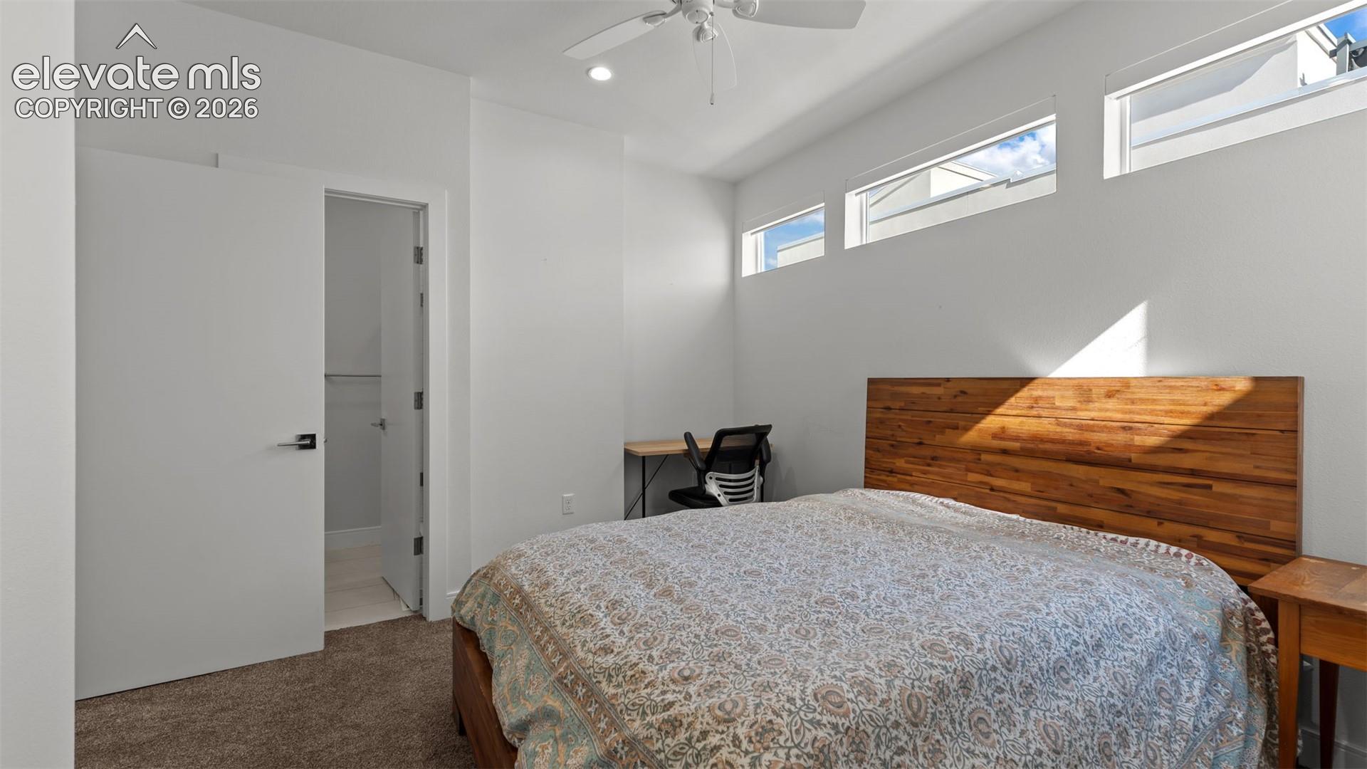 High-ceiling room featuring clerestory windows, recessed lighting, a white ceiling fan, and carpeted flooring