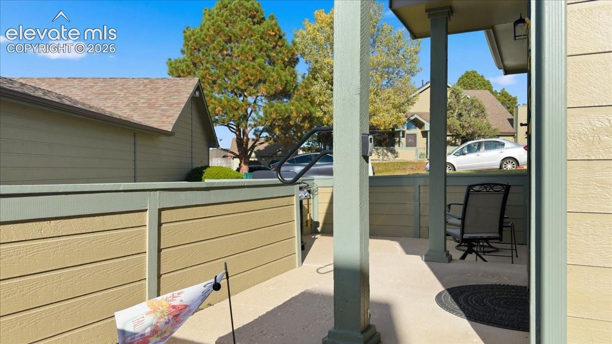 Covered patio featuring concrete flooring, horizontal lap siding, and square structural support columns