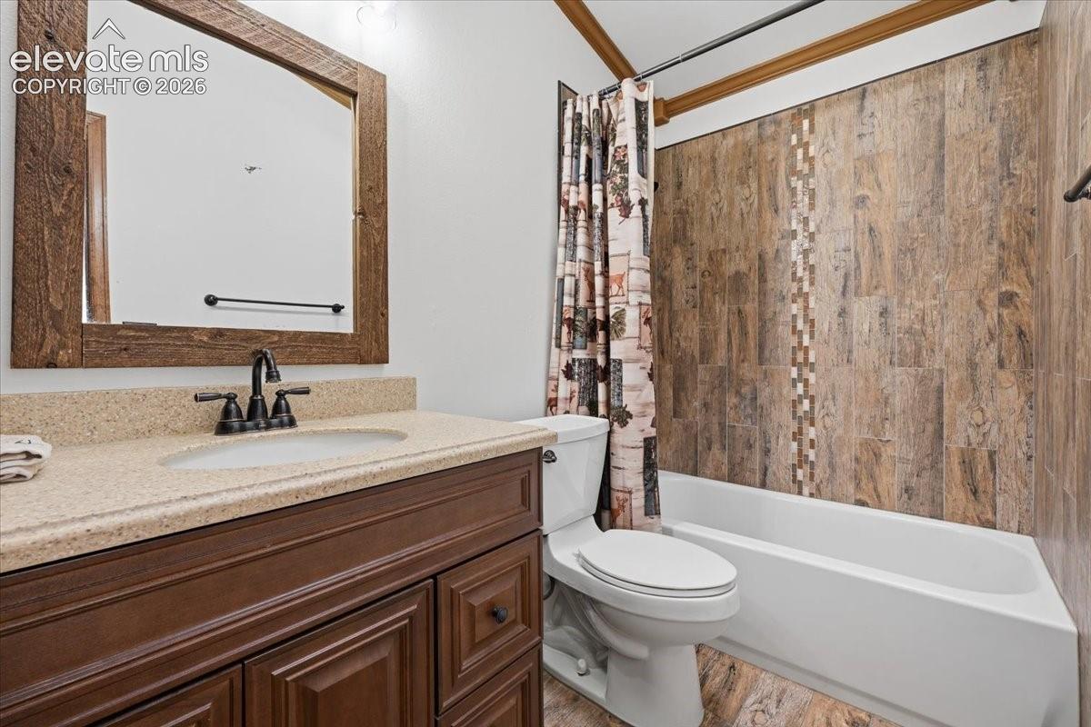 Vanity with a light-colored countertop, dark wood-finish cabinetry, and a rectangular mirror with a wood frame