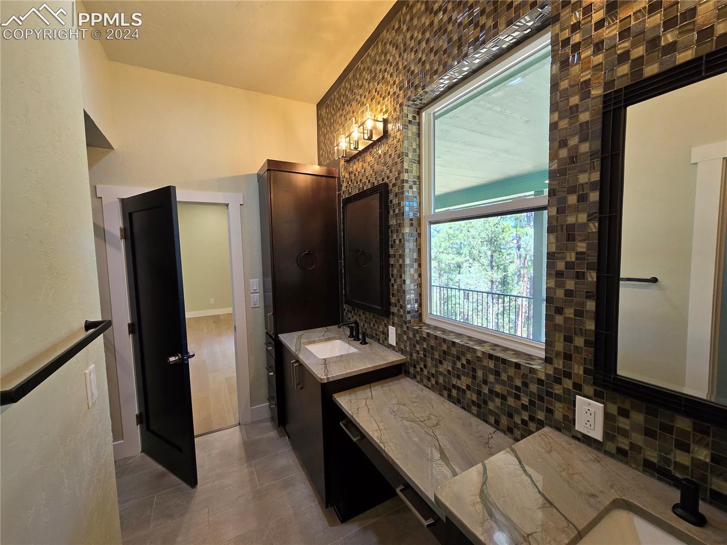Bathroom with tile patterned flooring, vanity, and tasteful backsplash