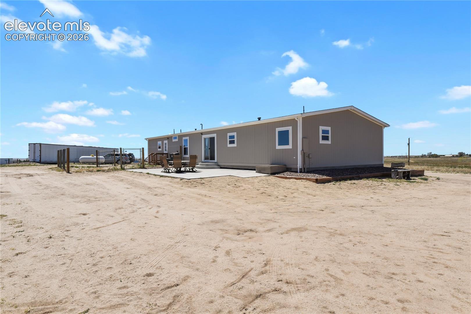 Exterior featuring vertical siding, concrete patio, and fenced perimeter