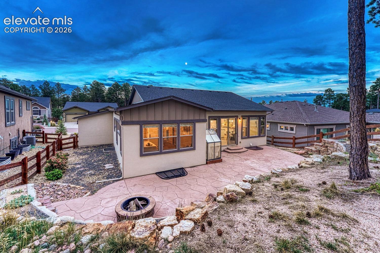 Huge custom stamped concrete patio with permanent firepit and tiered, xeriscape back yard that is fully fenced