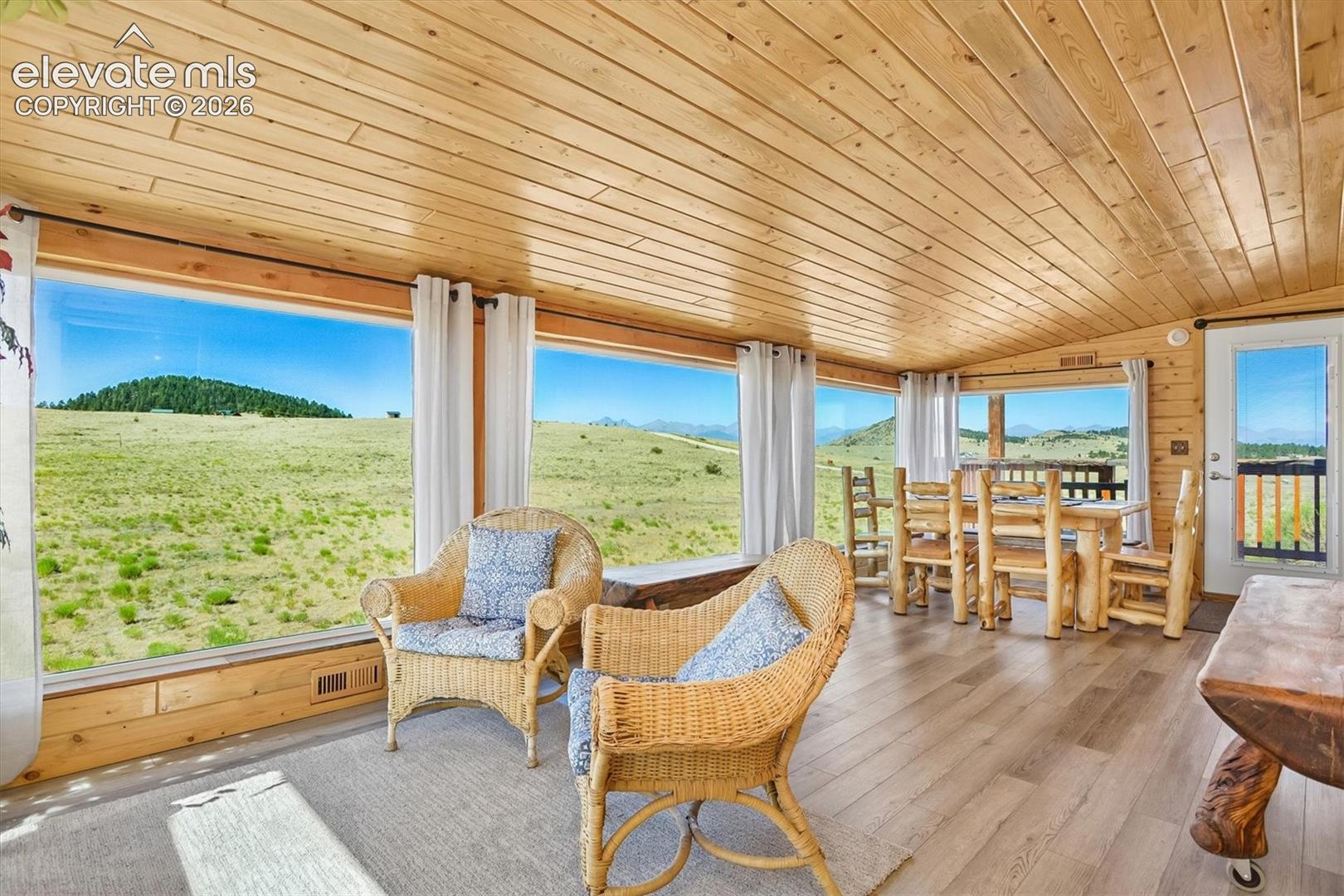 Interior space featuring extensive panoramic windows, wood-finish flooring, and a natural wood plank ceiling