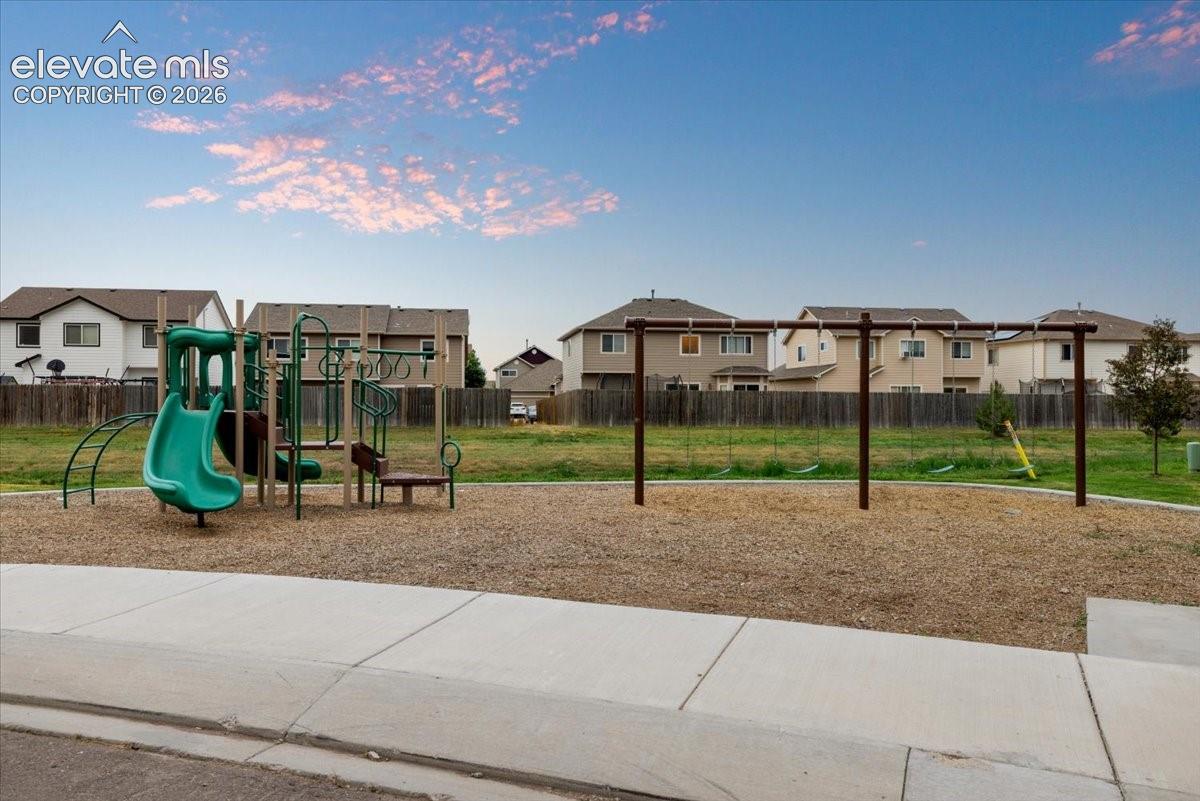 Community playground featuring a slide, climbing structure, and swing set