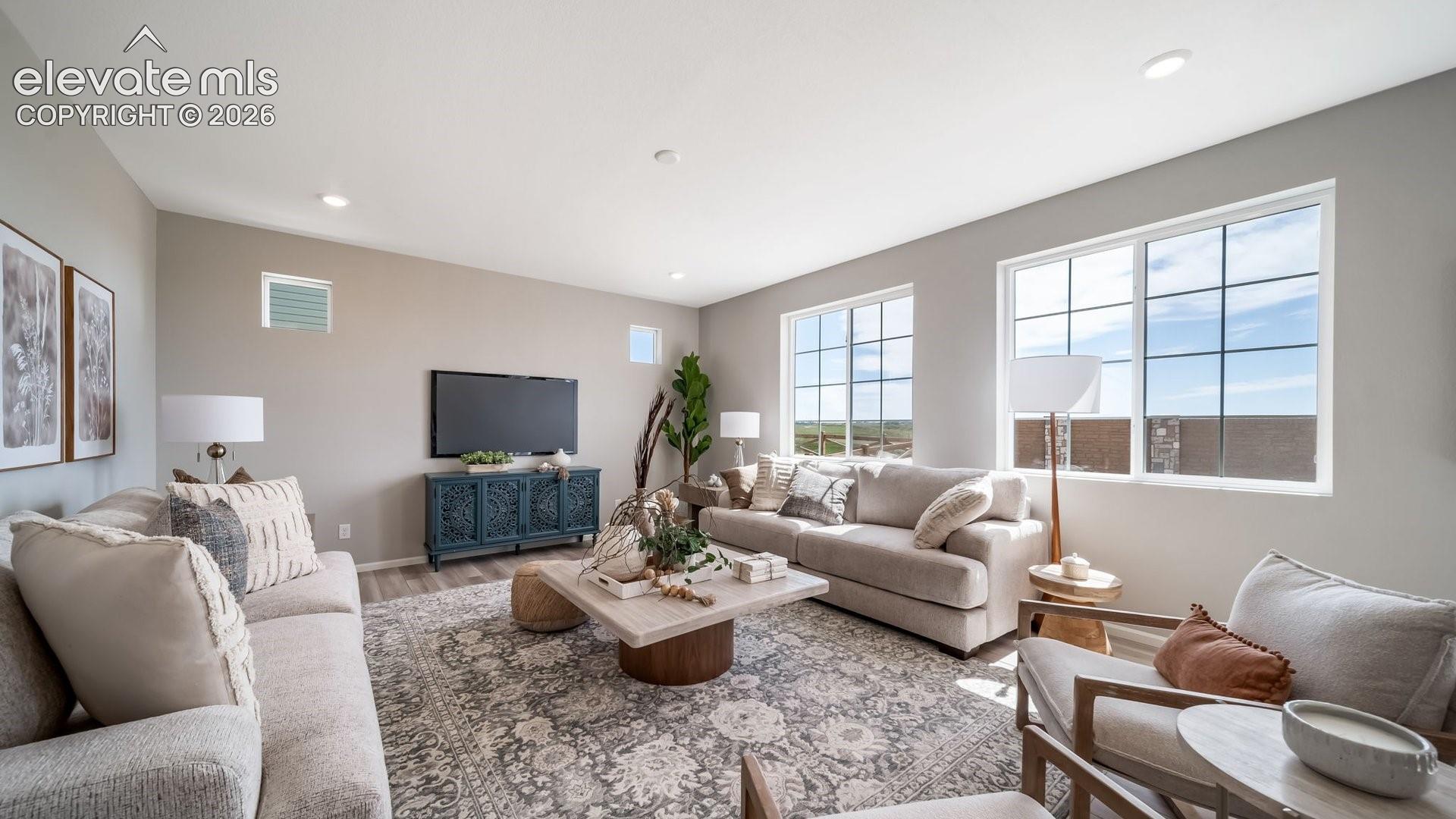 Spacious living area featuring light-toned walls, recessed lighting, and wood-finish flooring
Photos of a model home