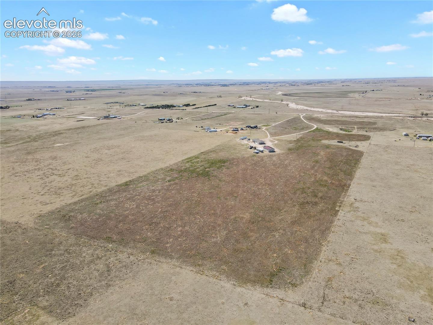Expansive parcel of land featuring open terrain, natural vegetation, and direct access to an unpaved road
