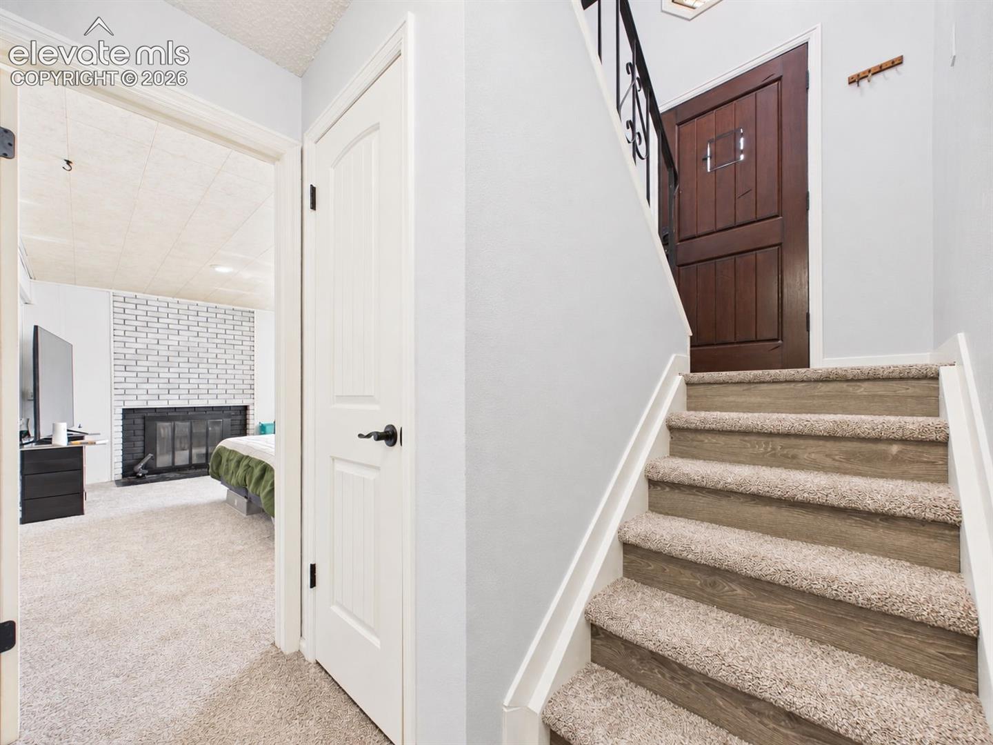 Split-level entry provides a clear view toward the adjacent bedroom and fireplace, with updated interior doors and coordinated neutral finishes.