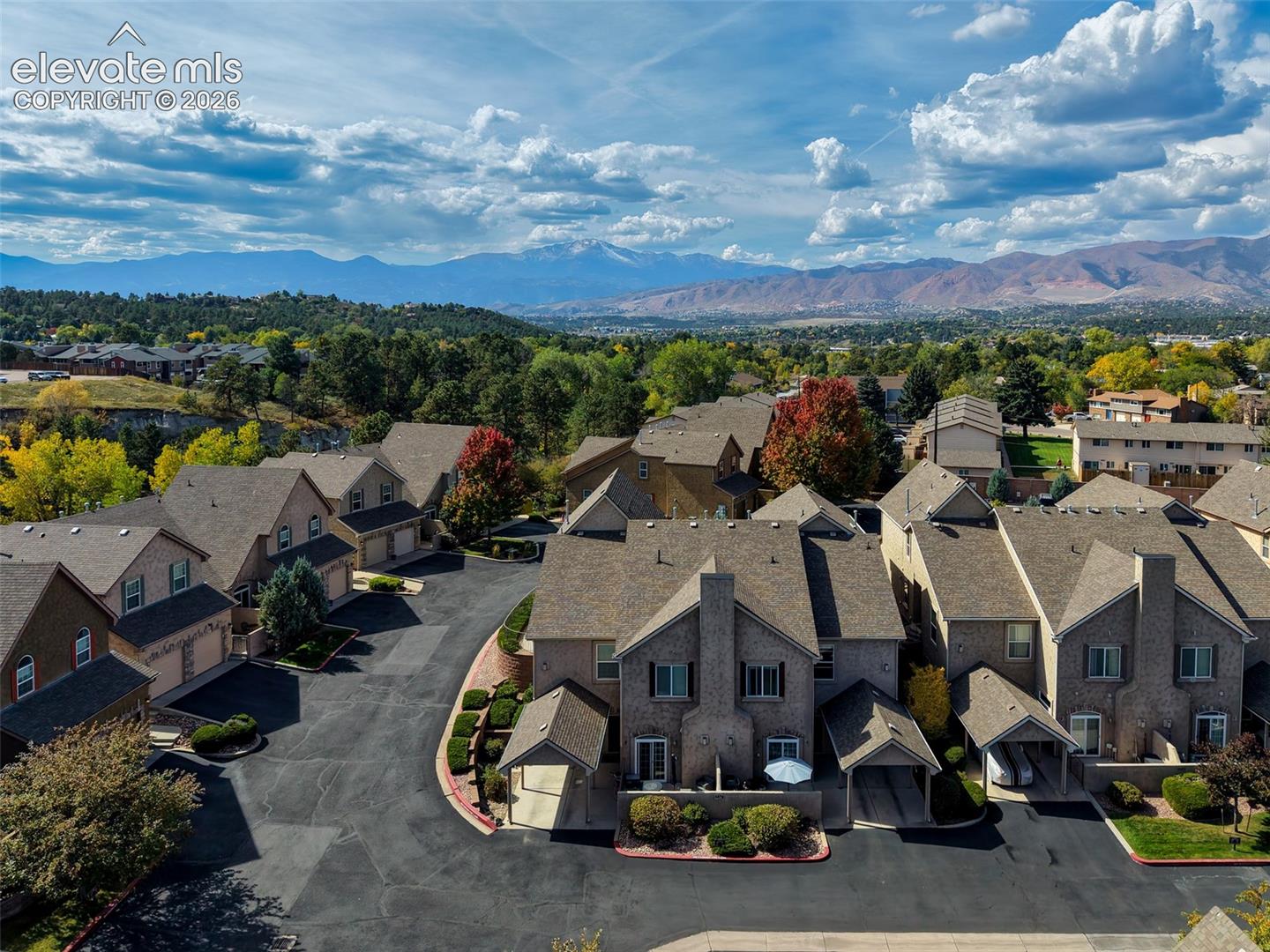 Mountain backdrop, brick facades, attached garages, mature landscaping, paved driveways