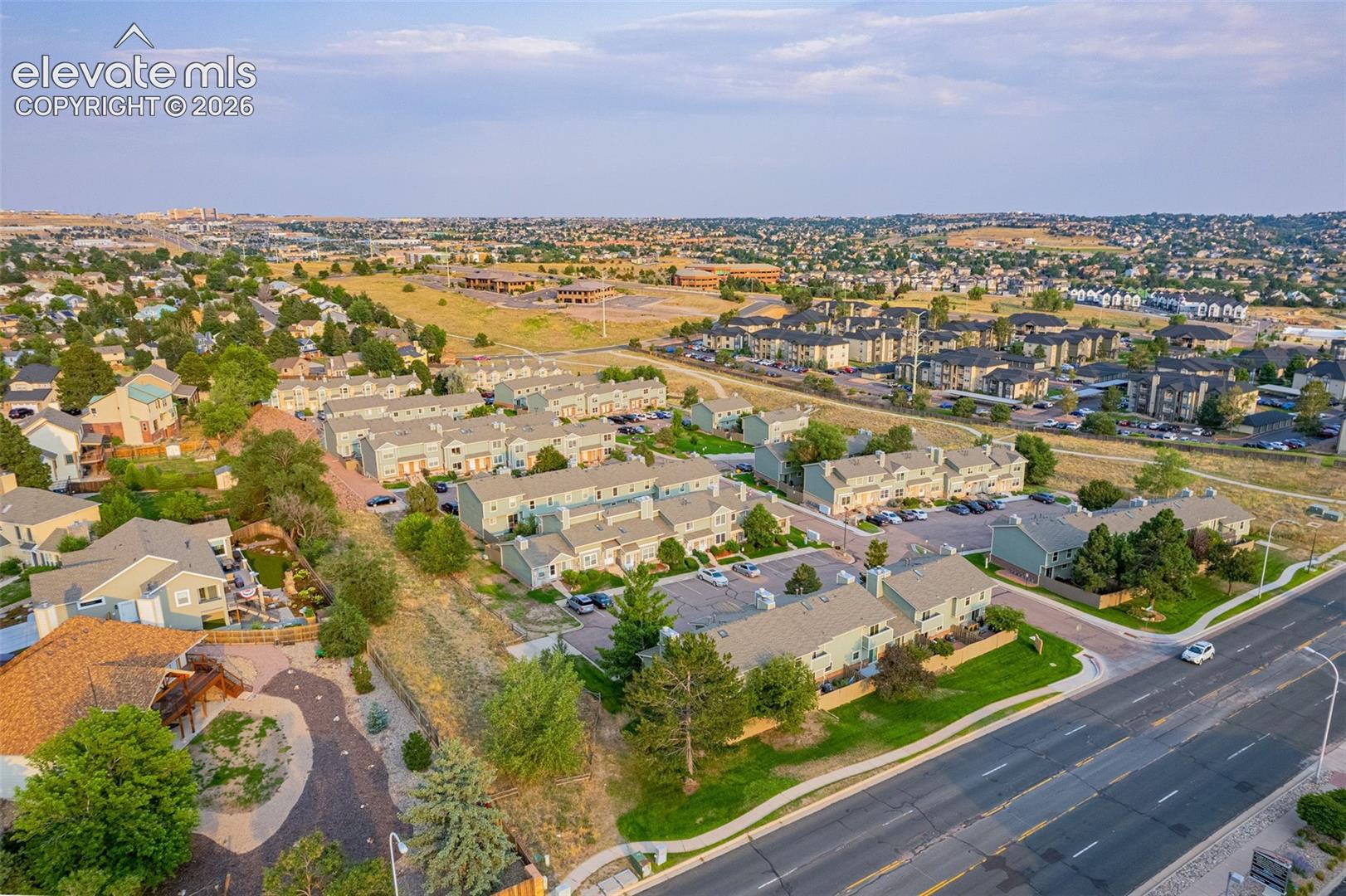 Aerial perspective showcasing a residential community with multi-story buildings, paved roadways, and landscaped grounds