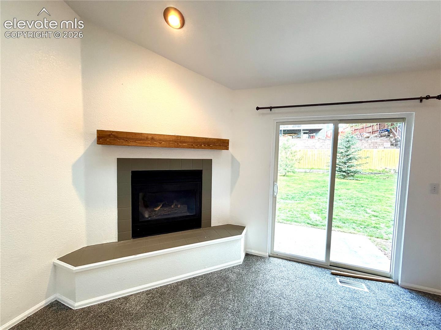 Corner fireplace featuring a wood-finish mantel and a built-in hearth