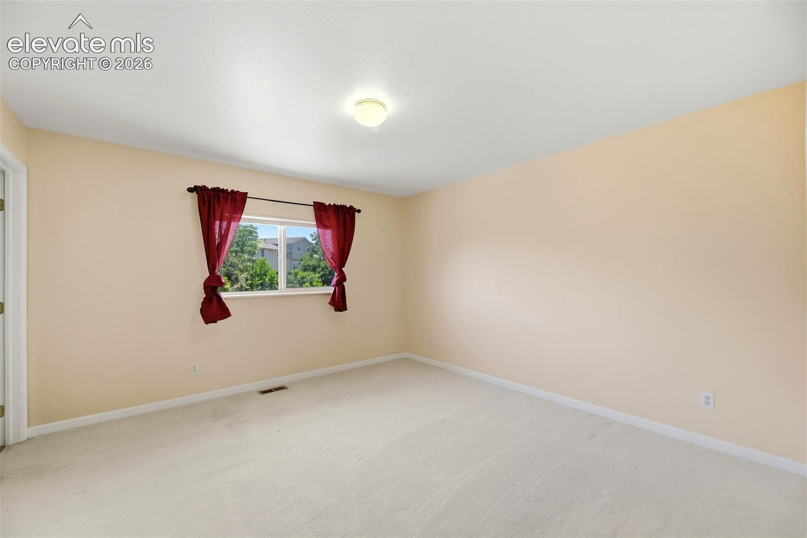 Bright interior space featuring light-toned carpeting and walls