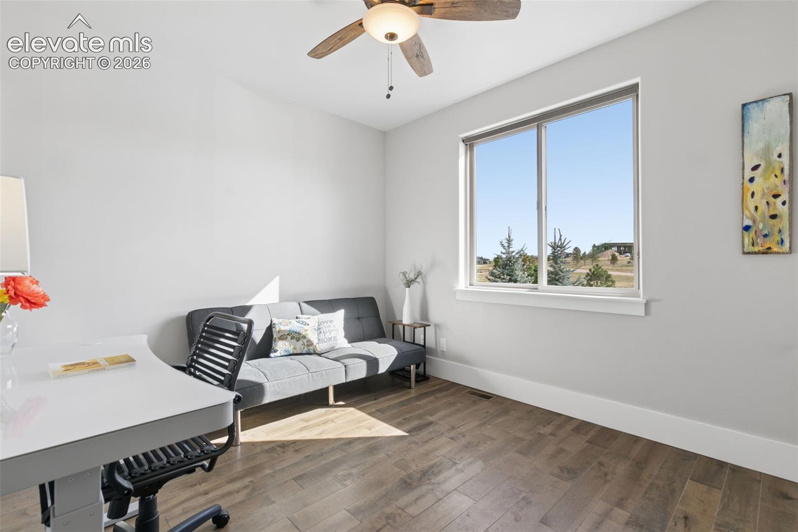 Wood-finish flooring, light-toned walls, and a ceiling fan with integrated lighting