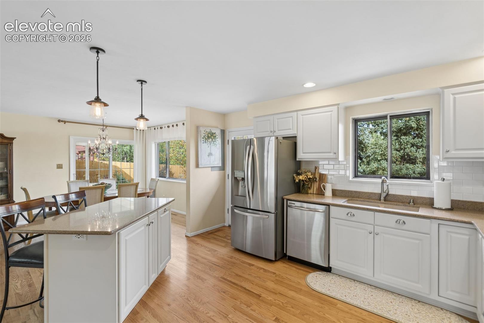 Kitchen has island for additional seating and storage including pull-out double trash cans. Window overlooks the back Trex deck