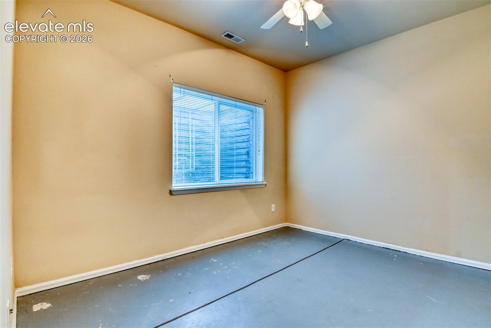 Vaulted ceiling featuring a central ceiling fan with an integrated light fixture and a single rectangular window