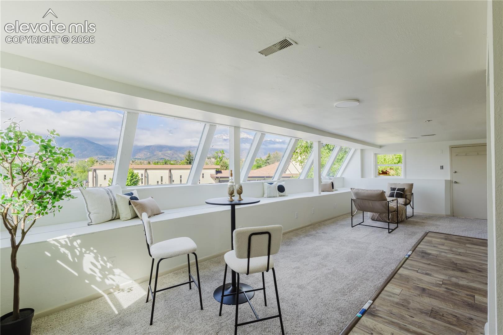 Bright upper-level space featuring a continuous bank of angled windows