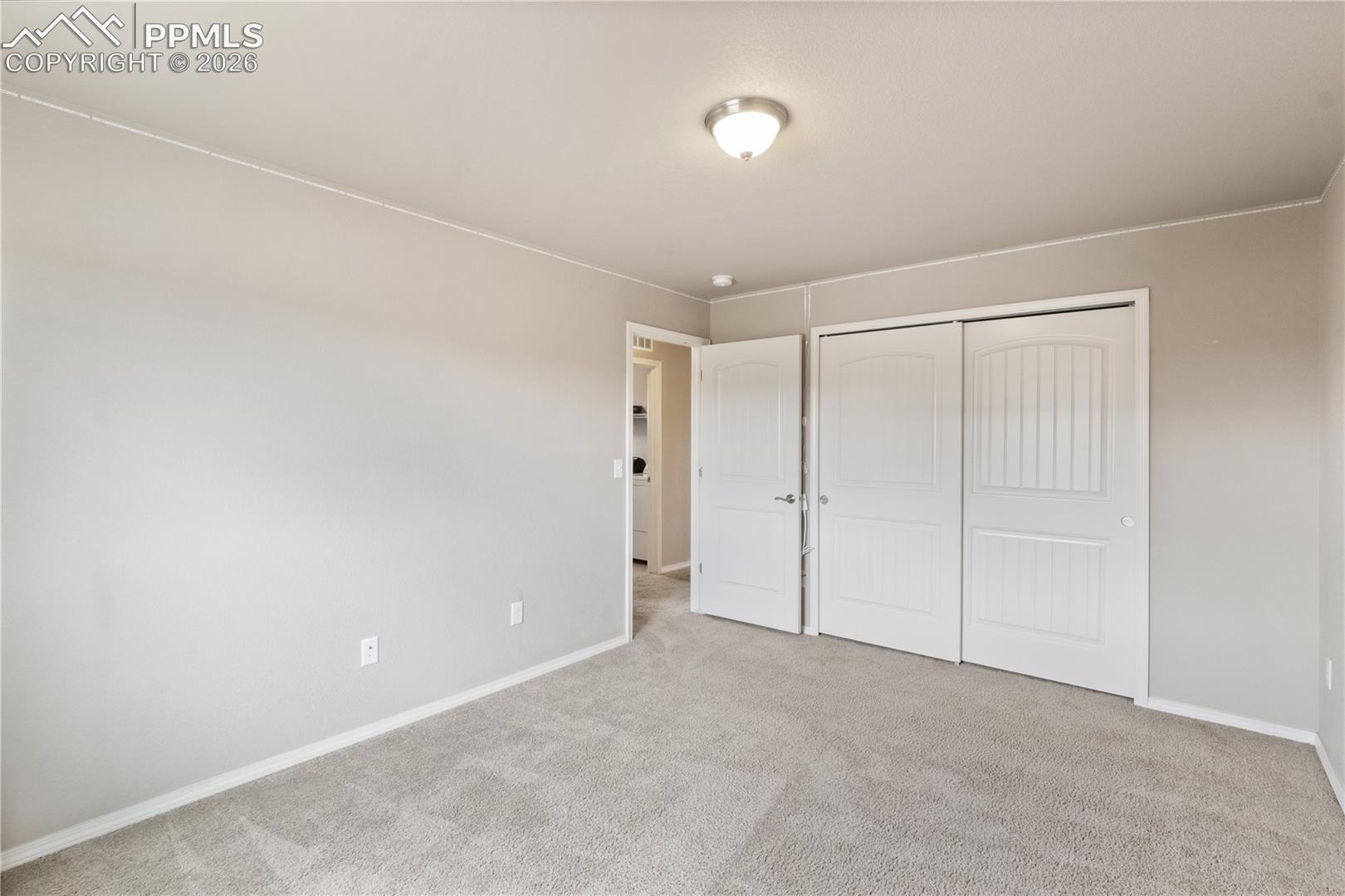Bedroom featuring light colored carpet and a closet