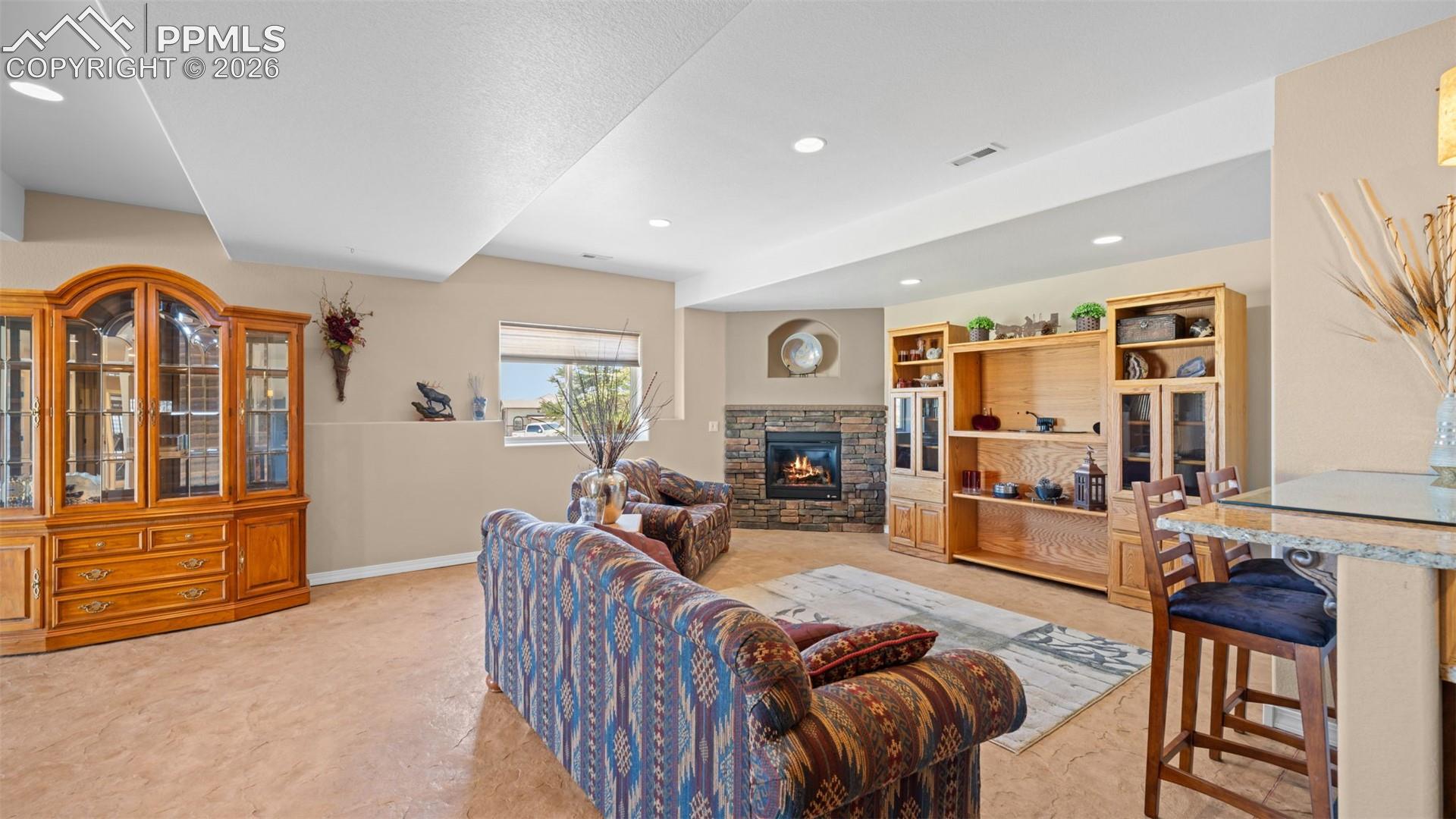 Living area with a stone fireplace and recessed lighting