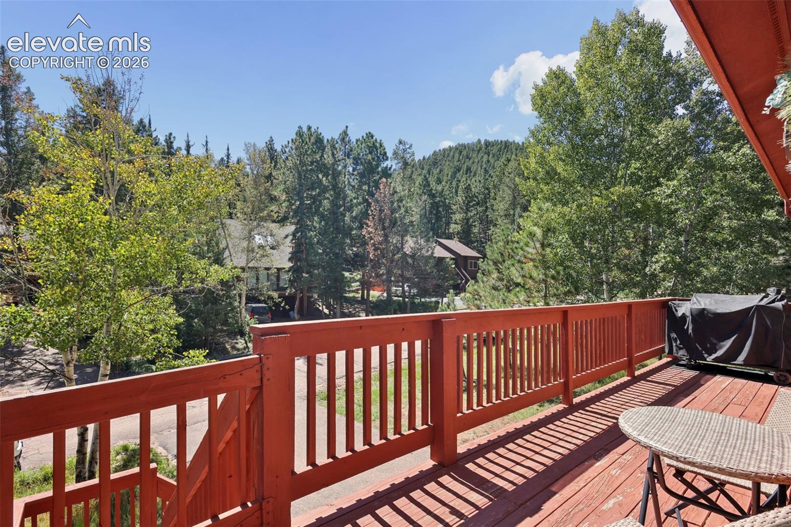 Expansive outdoor deck with red-painted railings and wood-finish flooring