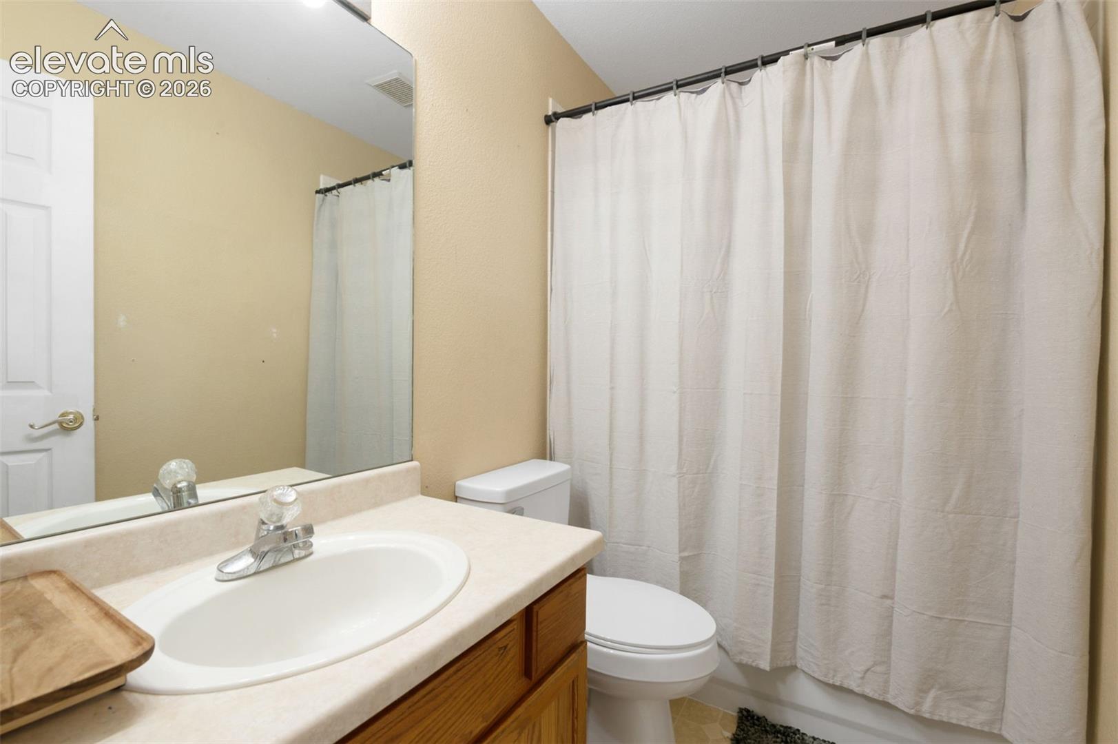 Bathroom vanity featuring an integrated sink with a chrome faucet, set within a light-toned countertop