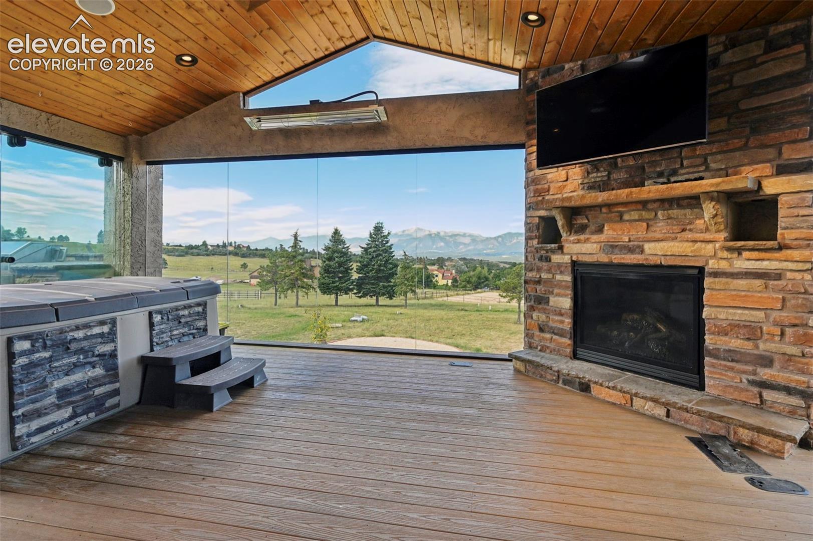 Bringing the outdoors in with Glassed In Sun room w hot tub and gas fireplace and radiant heat