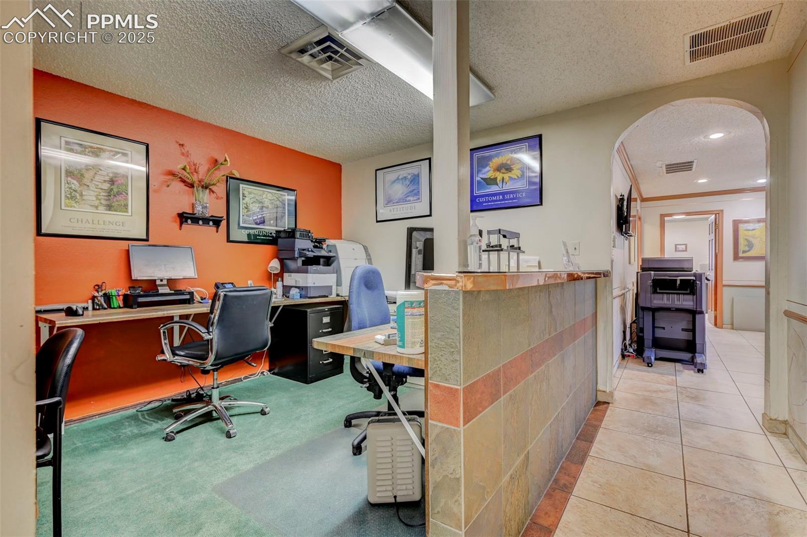 Tiled office space with arched walkways and a textured ceiling