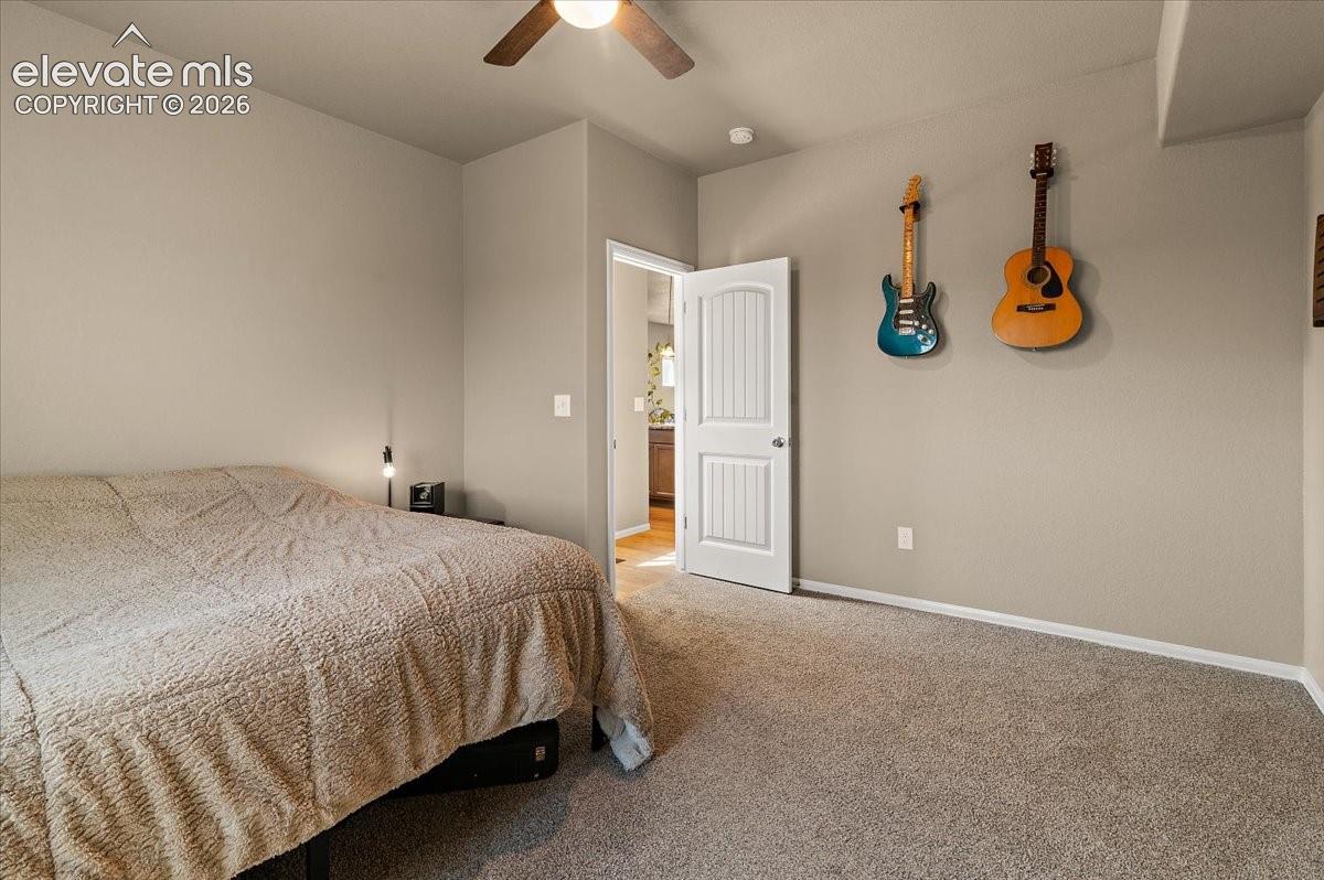 Wall-to-wall carpeting with neutral wall tones and a ceiling fan