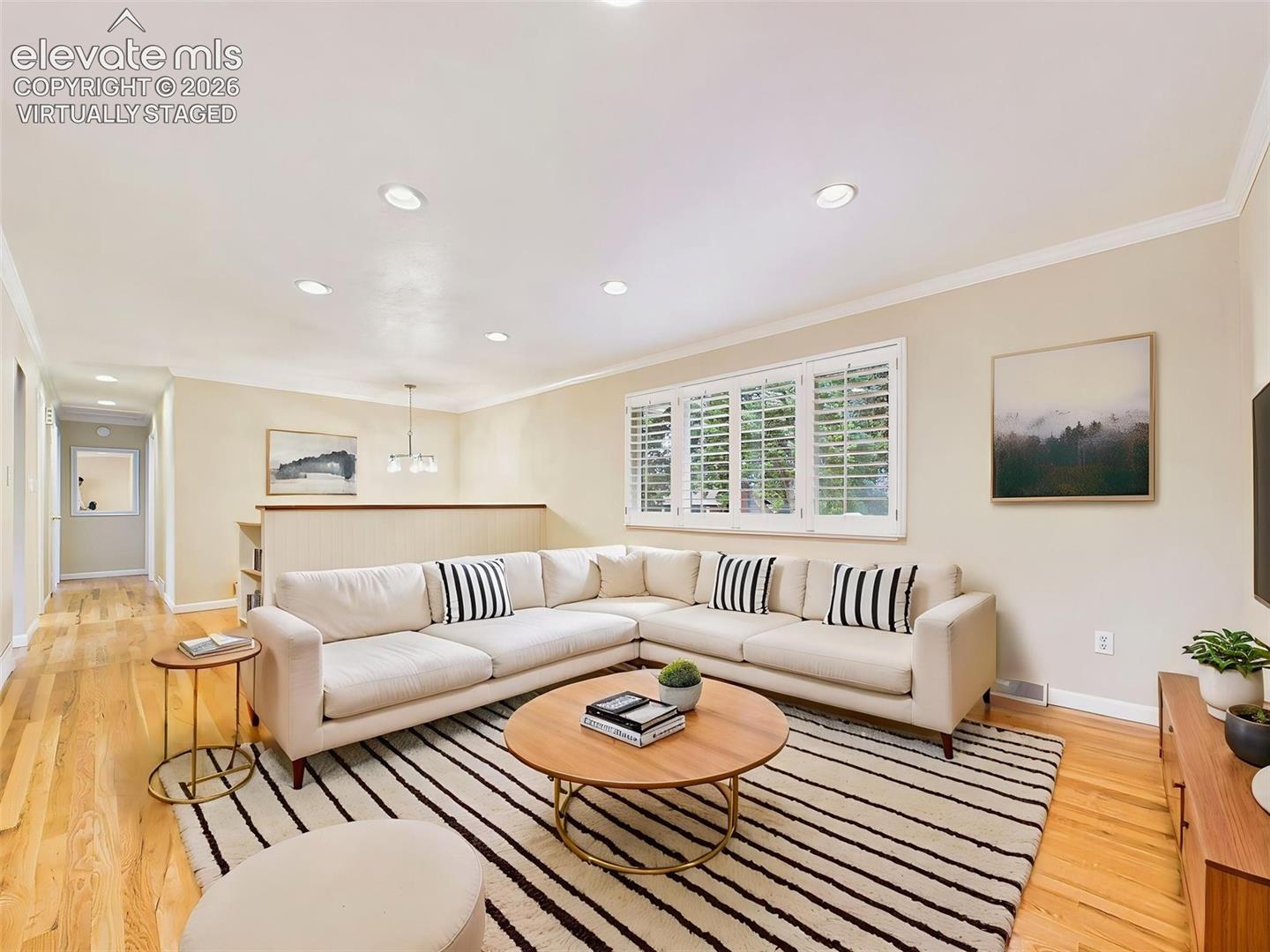 (Virtually Staged) Living Room – The generous living room creates a comfortable gathering space with refinished hardwood floors, plantation shutters, and seamless flow to the rest of the main level.