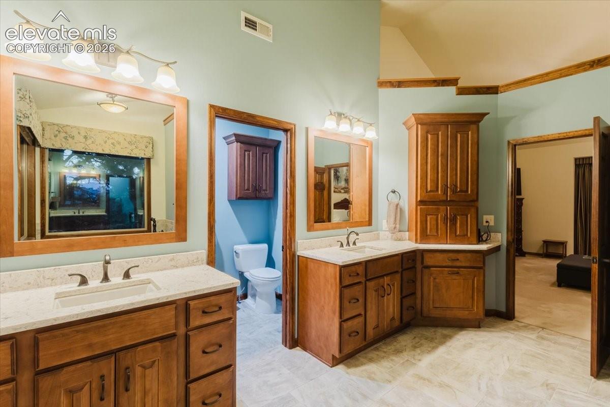 Dual vanity featuring light-toned countertops and wood-finish cabinetry