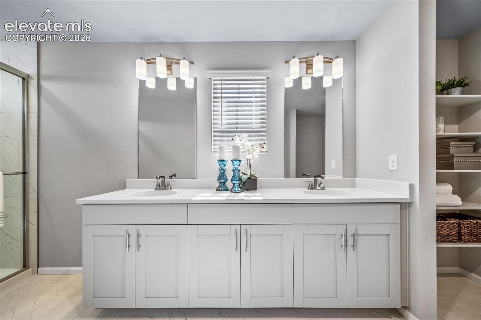 Double vanity with dual undermount sinks, quartz countertop, and white shaker-style cabinetry
*photos of a model home*