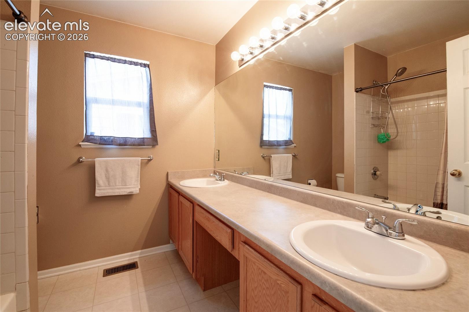 Double vanity featuring two oval sinks with chrome faucets, set in a light-toned countertop