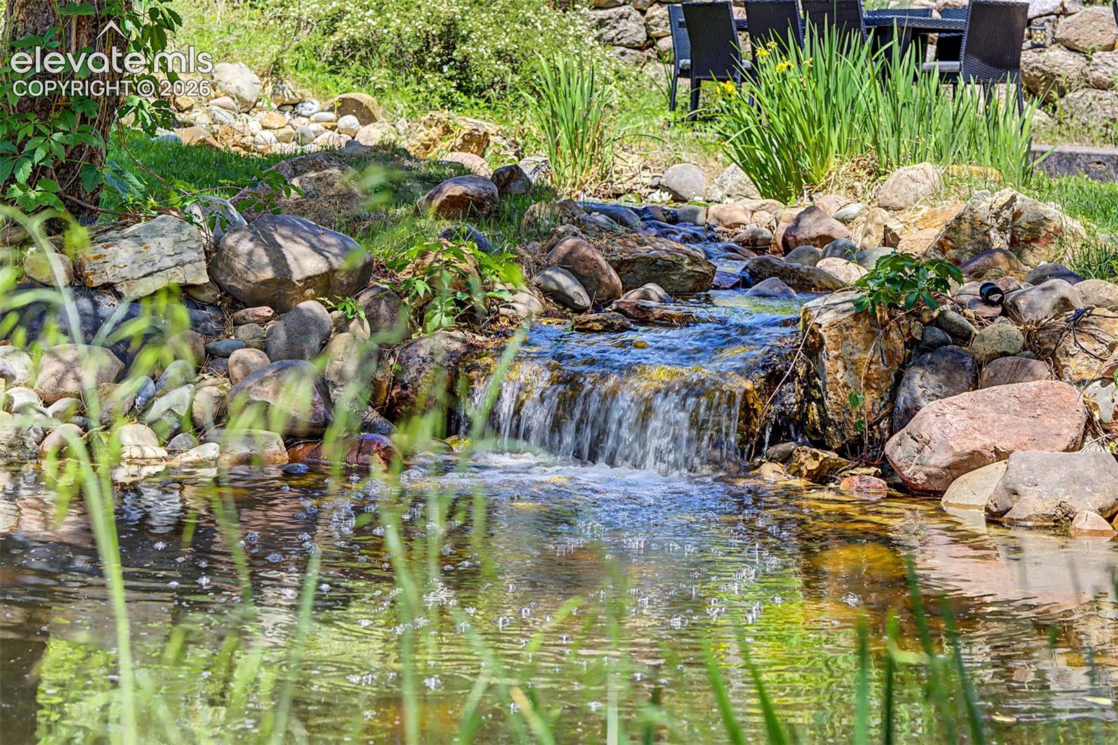 A pond and rock waterfall wind through the yard, bringing the sound of moving water right up to the back deck.