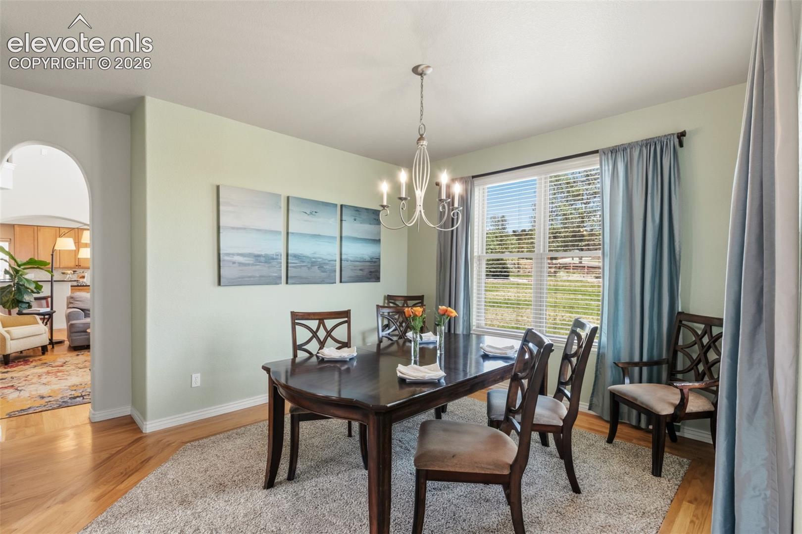 Dining area featuring wood-finish flooring and a central chandelier