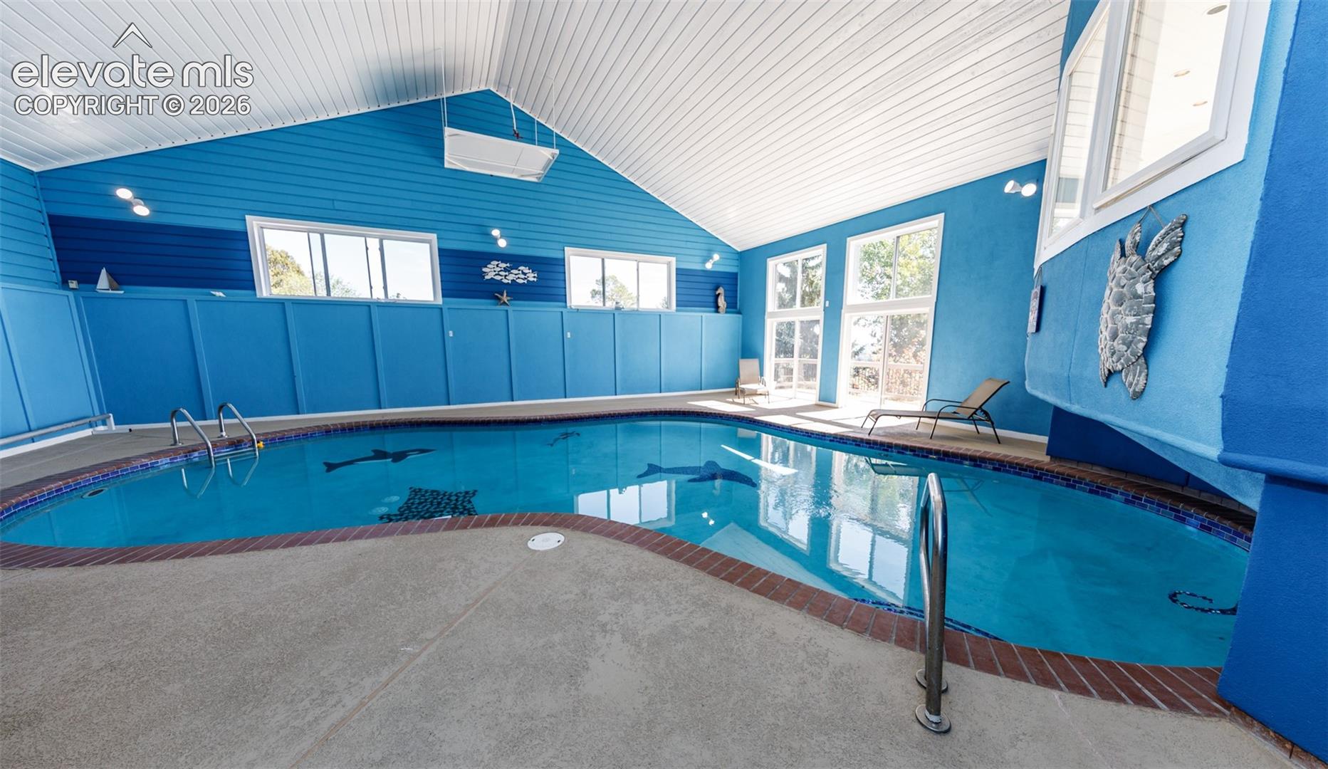 Very Large indoor pool with 2 sliding glass doors to the outside upper deck