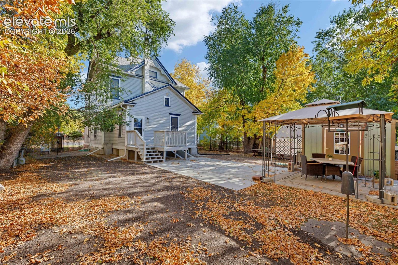 Exterior siding with a raised wooden deck, paved patio area, and detached structure