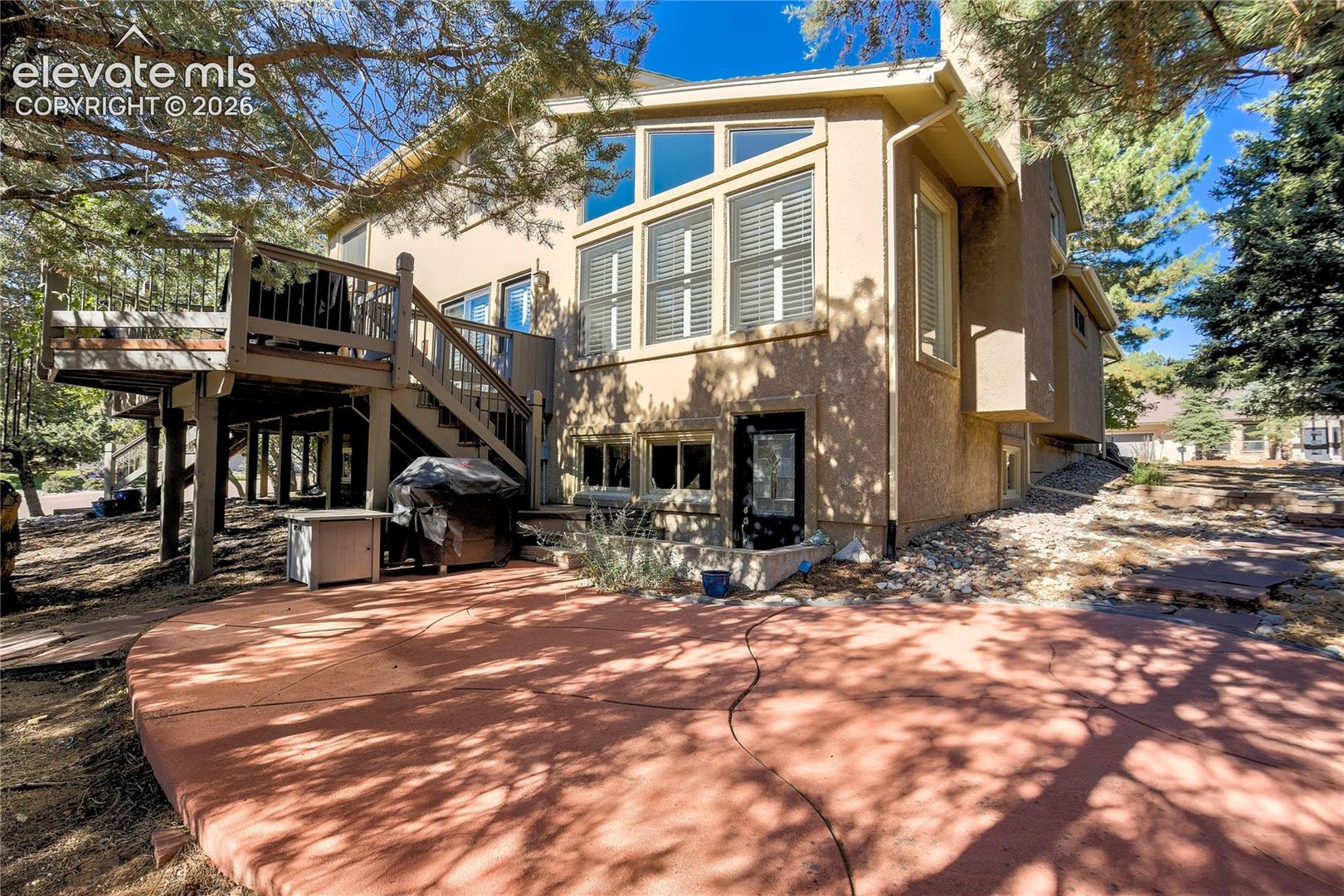 The lower patio extends outdoor living beneath the deck + is pre-wired for a future hot tub.