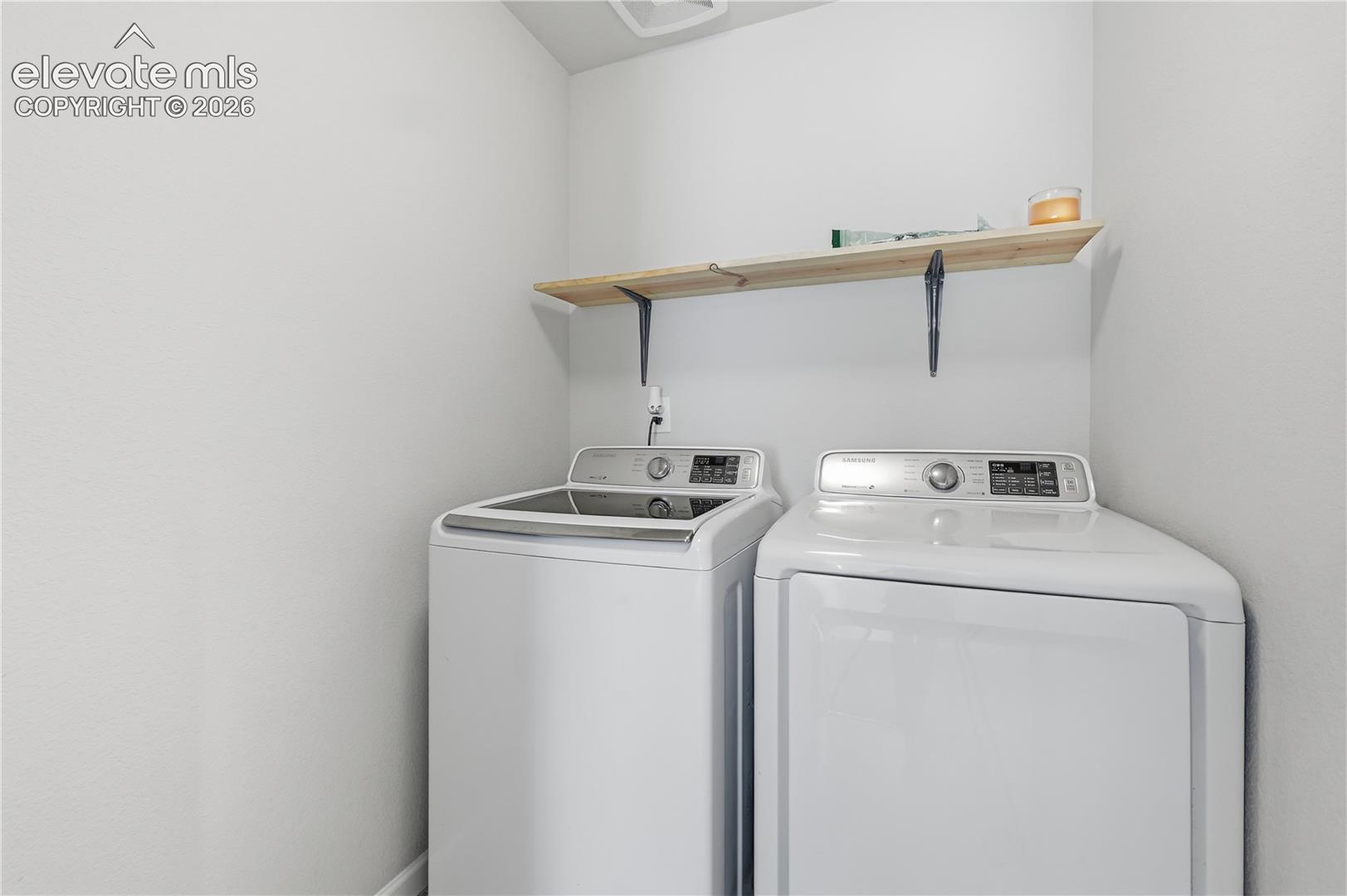 Dedicated laundry area with a top-load washer and front-load dryer