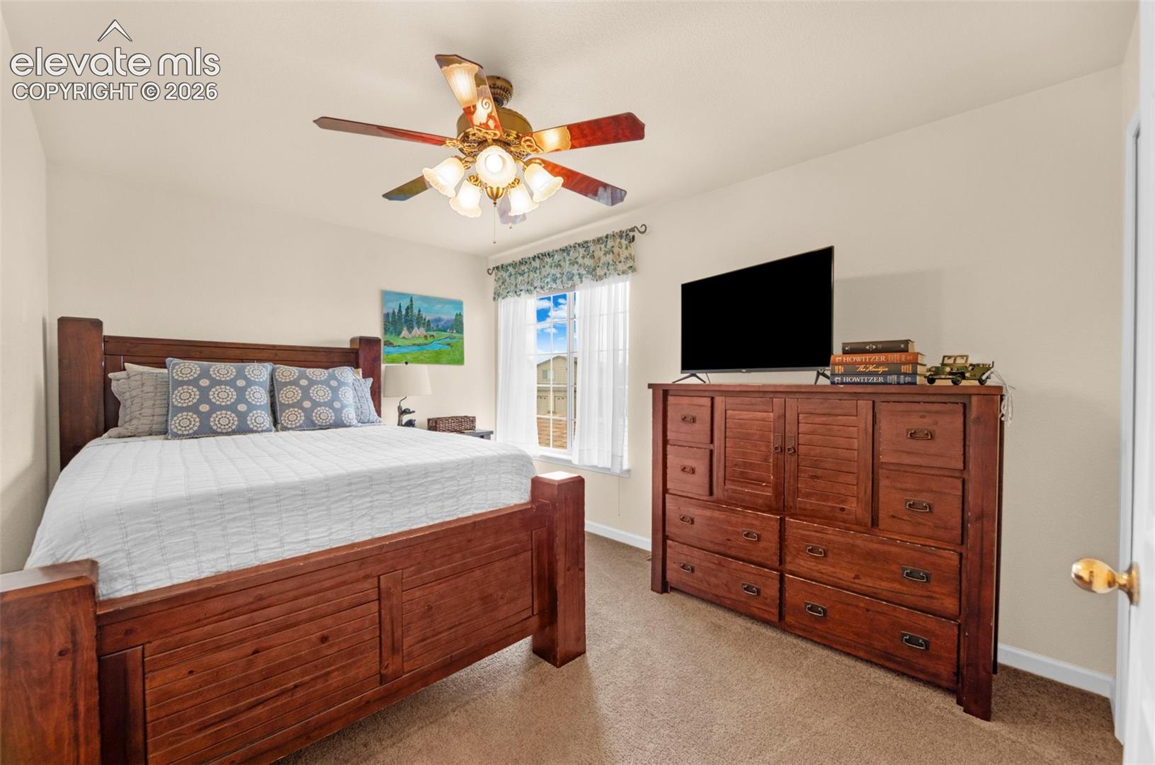 Bedroom featuring neutral wall paint, carpet flooring, a window with blinds, and a ceiling fan with integrated lighting