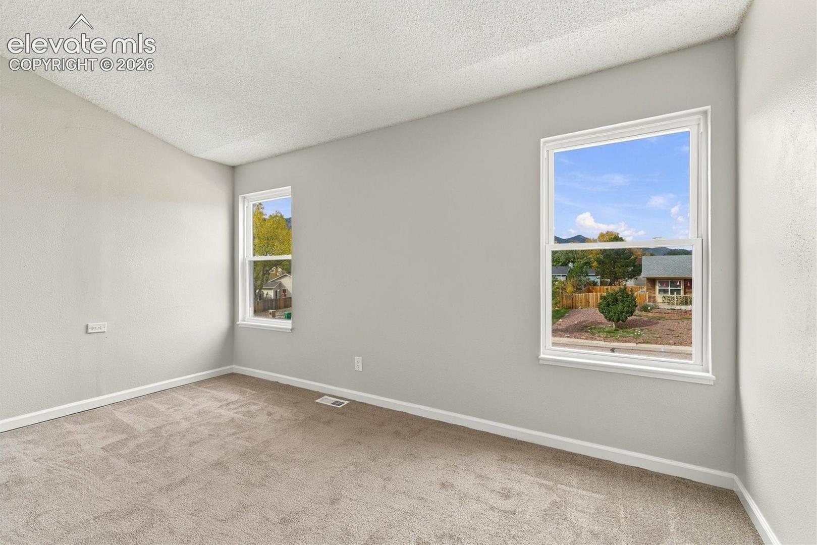 Room featuring neutral wall tones, wall-to-wall carpeting, and double-pane windows